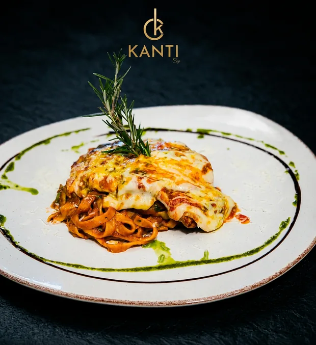 Poulet Parmigiana gratiné sur un lit de pâtes à la sauce tomate